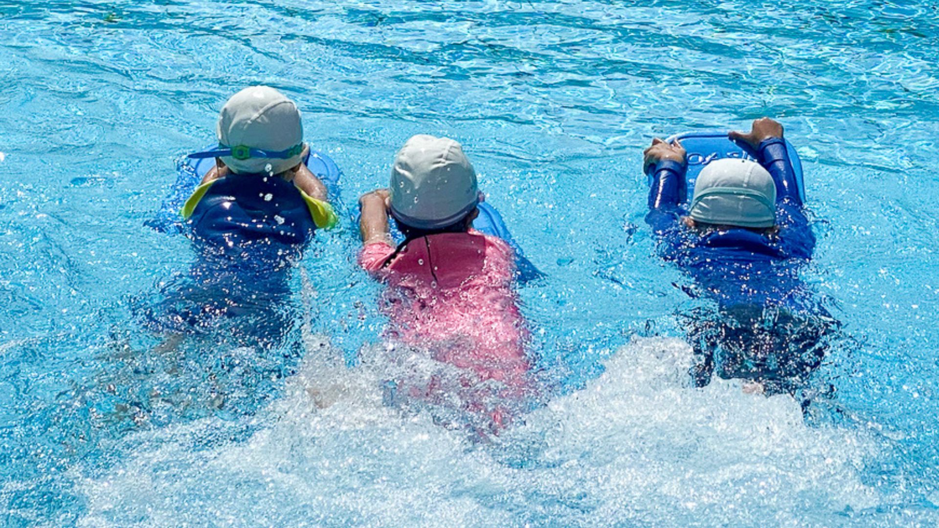 Three Kids Kicking in the Water at The Swim Lab