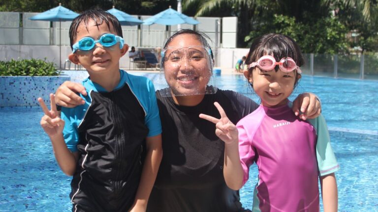 The Swim Lab Coach with Two Happy Students