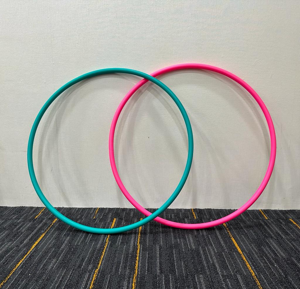 Colorful swimming hoops arranged poolside, set to introduce an element of fun and challenge in a children's swimming class.